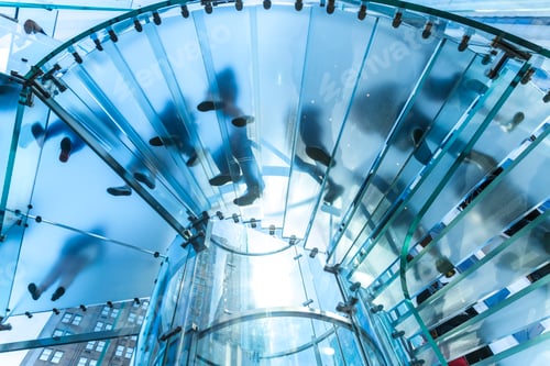 Preview: Low angle view of people walking on transparent spiral staircase.