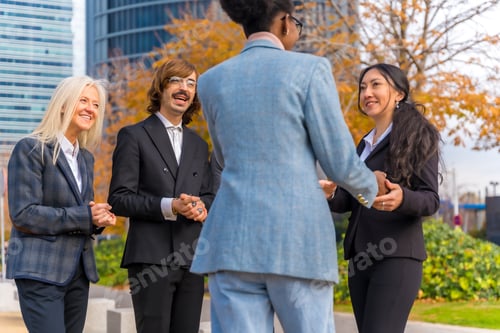 Preview: Middle-aged multi-ethnic businessmen and businesswomen shaking hands in good working environment
