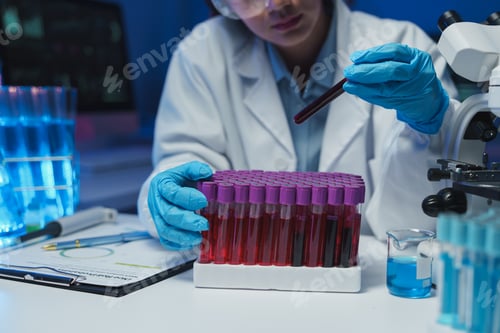 Preview: Scientist wearing gloves carefully examines blood samples in test tubes, conducting research in a mo