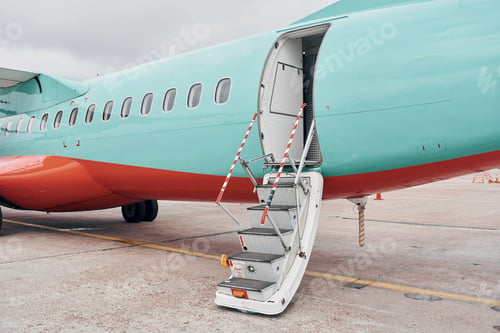 Preview: Doors is open. Turboprop aircraft parked on the runway at daytime