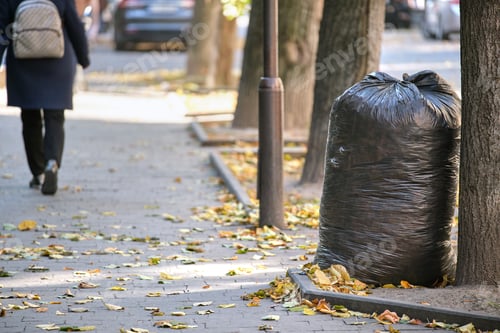 Preview: Pile of black garbage bags full of litter left for pick up on street side. Trash disposal concept
