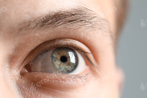Preview: Perfect vision. Man with beautiful eyes on grey background, closeup