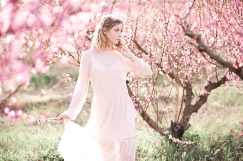 Preview: Beautiful blonde teenage girl in peach orchard outdoor