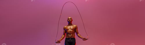 Preview: Man skipping with jump rope on studio background. Strength and motivation. Best cardio workout