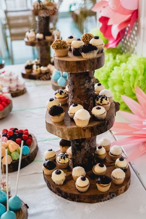 Preview: Desserts and wedding cake with very sweet cupcakes at an event.