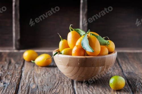 Preview: Fresh kumquat with green leaves on the wooden table