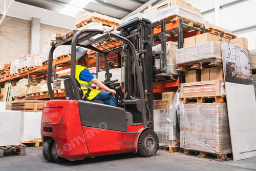 Preview: Spanish woman worker using a forklift in a warehouse