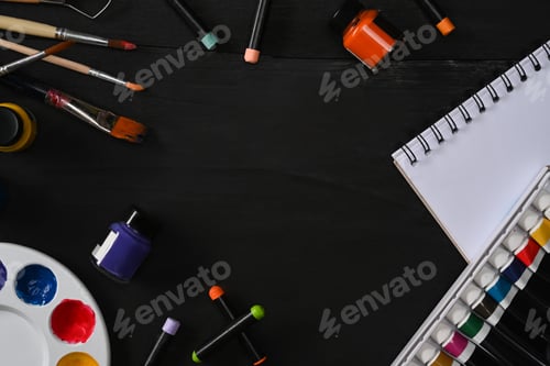 Preview: Artist workspace with sketchbook paint brushes, tube paint, watercolor and palette on blank wooden t