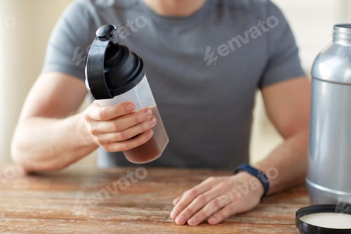 Preview: close up of man with protein shake bottle and jar
