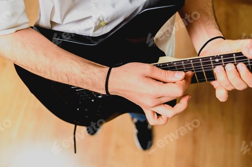 Preview: Fingers of a guitarist placed on the fret of the mast of the guitar playing a chord doing Tapping.