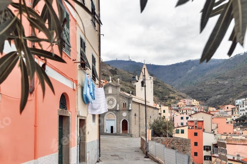 Preview: Old pink house and Basilica Church of St. John Baptist in Riomaggiore Cinque Terre, Italy