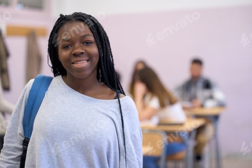 Preview: Smiling black student girl standing in classroom at institute