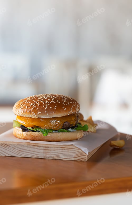 Preview: Freshly prepared burger on wooden board with copy space