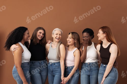 Preview: Stylish women of different ages having fun while wearing jeans and undershirts over brown background
