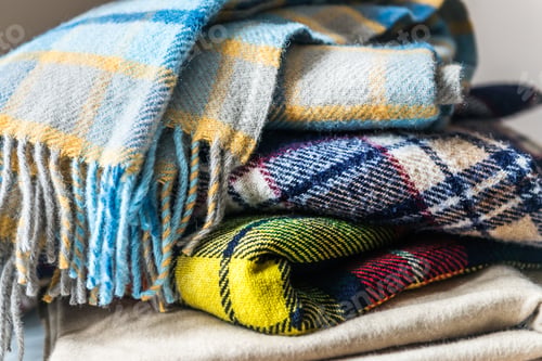 Preview: Stack of woolen checked blankets