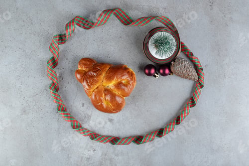 Preview: Sweet bun surrounded by a colorful ribbon on marble background