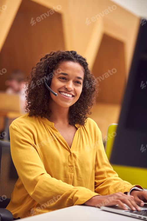Preview: Businesswoman Wearing Phone Headset Talking To Caller In Busy Customer Services Centre