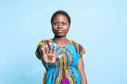 Preview: African american serious woman showing stop sign with her palm