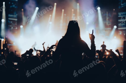 Preview: Silhouette of a woman with raised hands on a concert