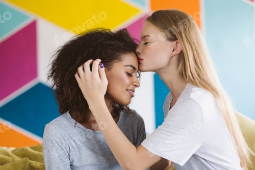 Preview: Young pretty woman with blond hair dreamily kissing forehead of
