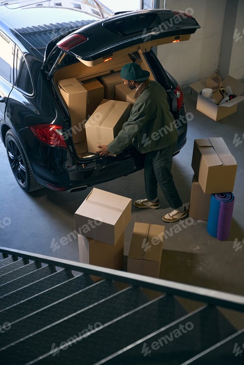 Preview: Young man takes boxes out of a car in a storage service