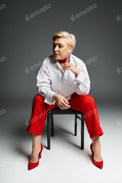 Preview: A fashionable woman showcases her chic outfit and poised demeanor in a studio space