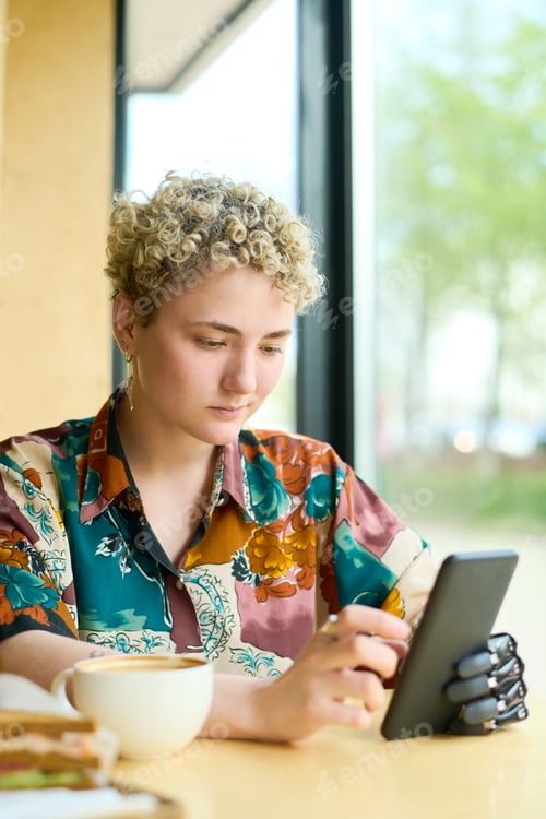 Preview: Young woman with partial arm scrolling through online videos in smartphone