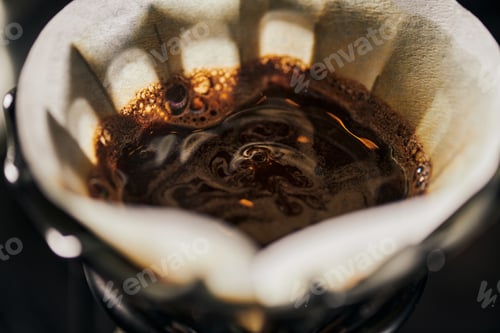 Preview: close up view of black freshly brewed coffee with foam in filter bag, alternative V-60 espresso brew