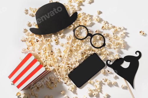 Preview: Delicious popcorn, party props and smartphone with blank screen for your design