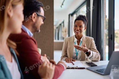 Preview: Happy black insurance agent communicating with her clients during a meeting.