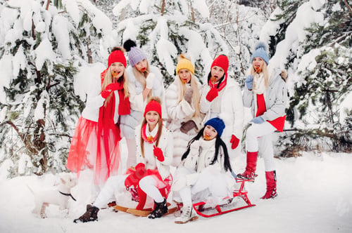 Preview: A large group of girls with lollipops in their hands stands in the winter forest.Girls in red and