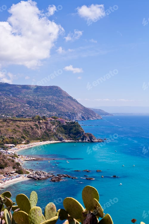 Preview: View of turquoise gulf bay, sandy beach, green mountains and plants, blue sky white clouds
