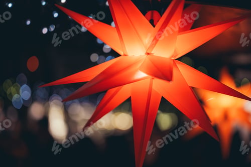 Preview: Red colored stars illuminated with light on Xmas tree at Christmas Market in Hamburg, Germany