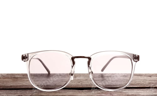 Preview: Glasses on wooden table against white background. Ophthalmologist consultation