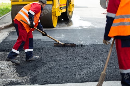 Preview: The road workers' working group updates part of the road with fresh hot asphalt.
