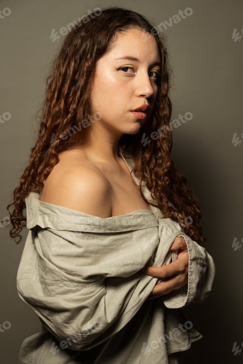 Preview: Woman posing with curly hair and bare shoulders