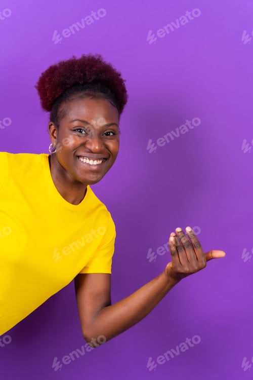 Preview: Portrait of a young cheerful black woman doing an inviting gesture