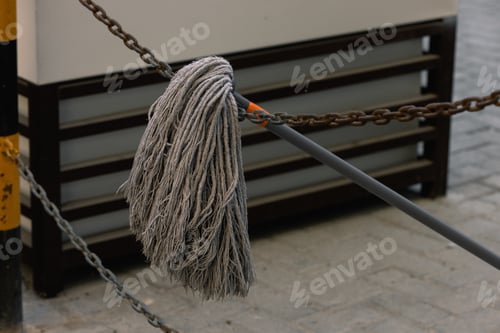 Preview: Dirty mop hanging from a chain used for mopping floors