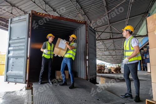 Preview: Worker carry carton box taken from 40 feet steel container on the trailer truck park at warehouse