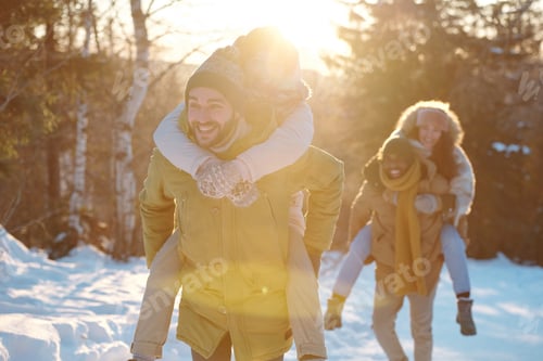 Preview: Two happy young couples in winterwear having fun on sunny day