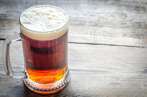 Vista previa: Mug with dark beer on the wooden table