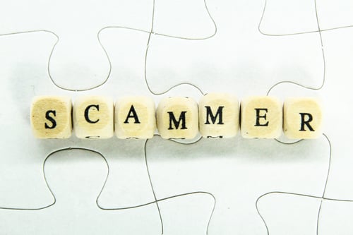 Preview: wooden cube with the word fraud or scammer.