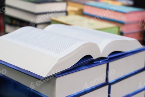 Preview: Open book on table with blur bookshelf background