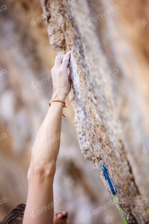 Preview: Cropped view of climber's hand on cliff