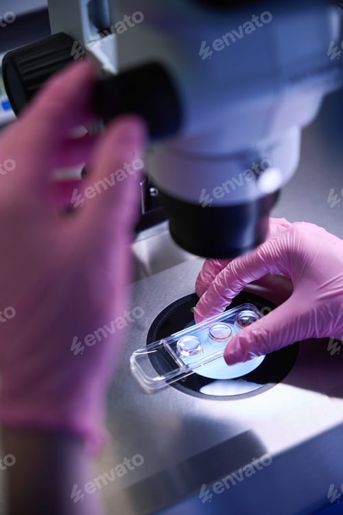 Preview: Doctor placing a sample under a microscope for analysis