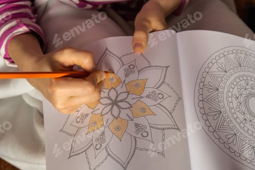 Preview: Woman coloring antistress page. Female hand painting mandala. Female painting mandalas to combat str