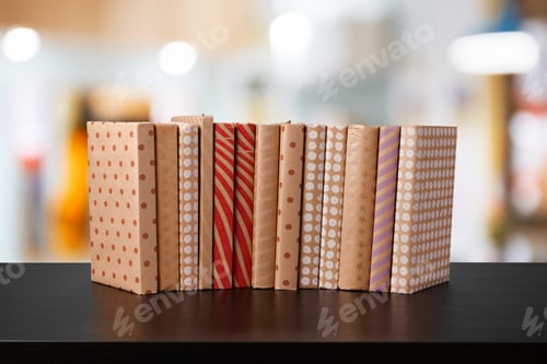 Preview: Stack of books on wooden table against blurred background