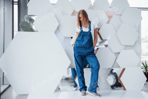 Preview: Girl in blue uniform stands against abstract wall