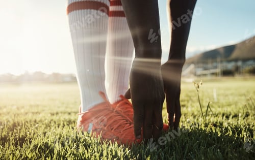 Preview: Soccer player, stretching legs on grass and hands on shoes on pitch for sport fitness training star