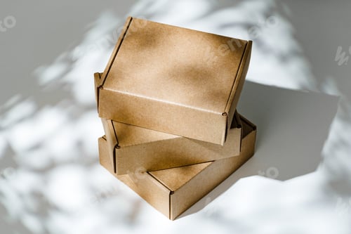 Preview: Freshly packed cardboard boxes resting on a white surface, illuminated by soft natural light